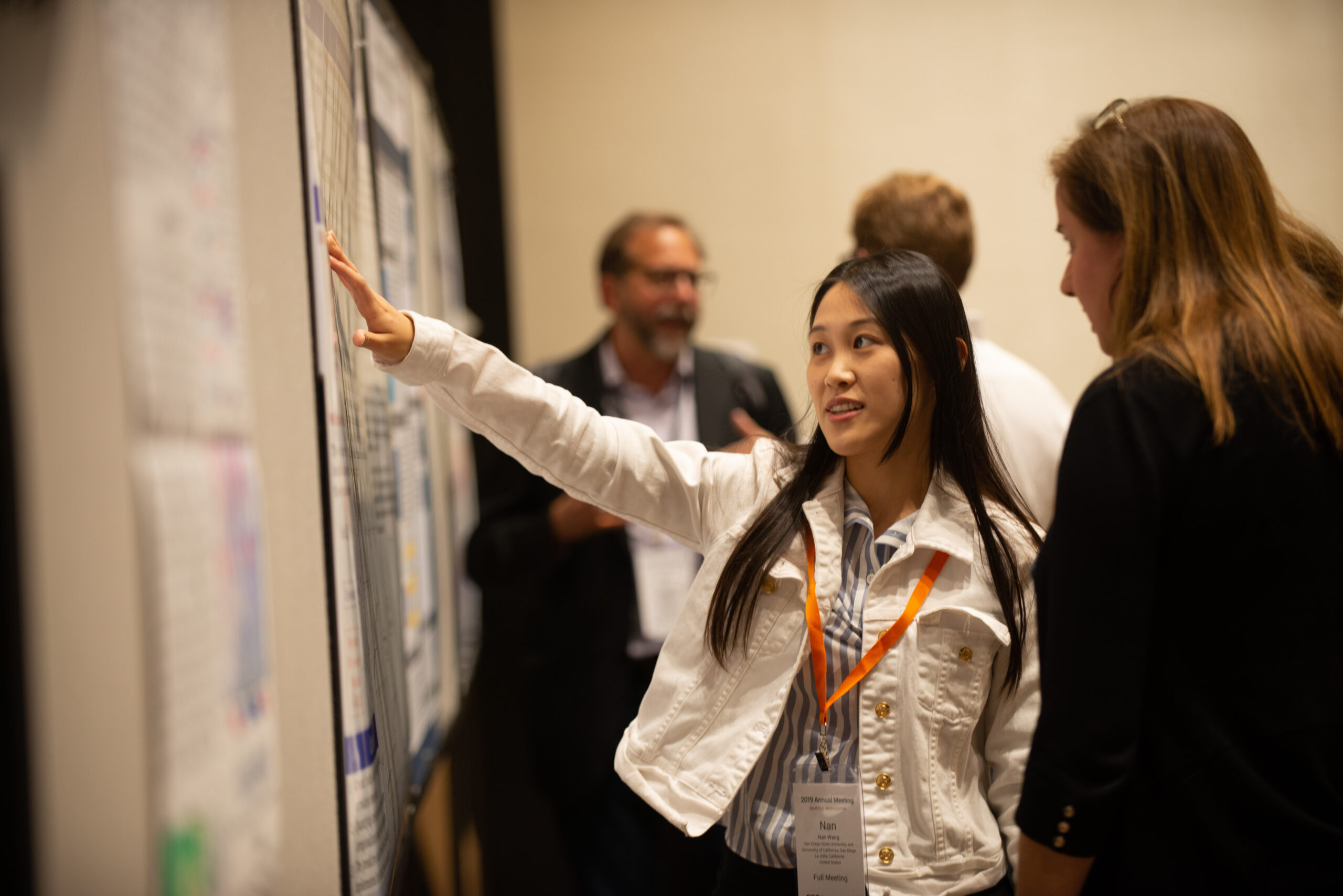 A presenter explains a poster to an attendee at the Annual Meeting 2023